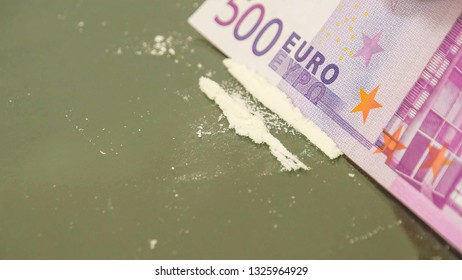 500 Euro paper bill cut the white powder into lines. With the hard and stiff paper Euro bill the white powder was cut into three pieces and lined on the table