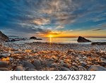 5:03 am. Looking across Belfast Lough at mid-summer sunrise at the beach below Grey Point on the North Down Coastal Path near Bangor, County Down, Northern Ireland.