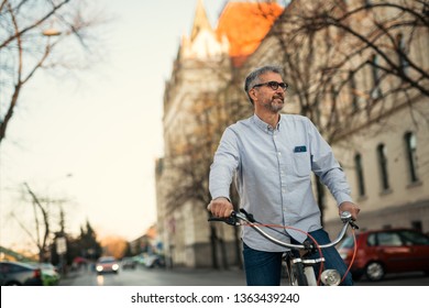 50-60 years old man riding bike in the city