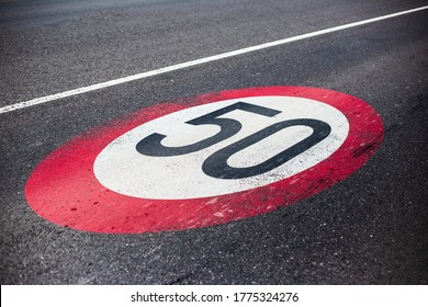 50km/h speed limit sign painted on asphalting road.
