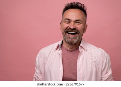 50s handsome bristle man in pastel-pink shirt excited smiling cheerfully posing isolated on pink background. People emotions Lifestyle concept - Powered by Shutterstock