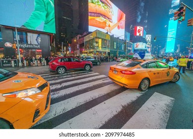 50th Street And Park Avenue, Yellow Taxi Cars Make A Left On A Green Light At Night, Manhattan, New York City, 10022, United States Of America. 12.18.2021