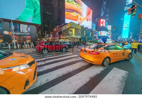 50th street and Park avenue, yellow\
Taxi cars make a left on a green light at night, manhattan, new\
york city, 10022, United States of America.\
12.18.2021