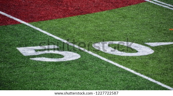 The 50-yard-line of an american football field with\
artificial turf