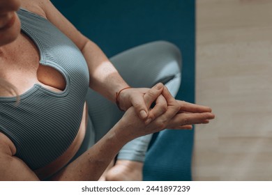 A 50-year-old woman does yoga at home - Powered by Shutterstock