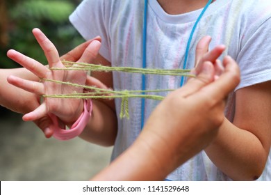 5-6 Years Old Asian Little Girl Playing String Game With Her Mother.Hands Playing String Game Creativity.A Popular String Game Is Cat's Cradle Or Rabbit's Cradle.Girl Enjoy And Fun.Creative Thinking.