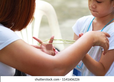 5-6 Years Old Asian Little Girl Playing String Game With Her Mother.Hands Playing String Game Creativity.A Popular String Game Is Cat's Cradle Or Rabbit's Cradle.Girl Enjoy And Fun.Creative Thinking.