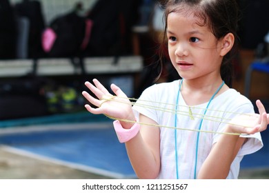 5-6 Years Old Asian Little Girl Playing String Game With Her Mother.Hands Playing String Game Creativity.A Popular String Game Is Cat's Cradle Or Rabbit's Cradle.Girl Enjoy And Fun.Creative Thinking.