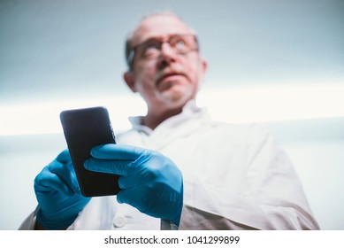  59  Year  Old Man With Smartphone And Latex Gloves