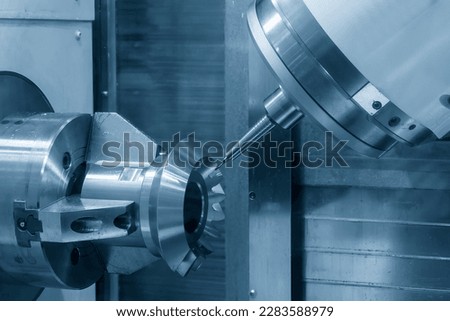 The 5-axis CNC milling machine  cutting the metal gear part. The hi-technology automotive part manufacturing process by CNC lathe.