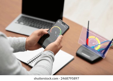 5G speed test. Man using mobile phone at table, closeup - Powered by Shutterstock