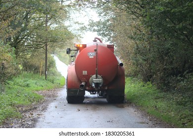 5th October 2020- A Red Hi Spec Slurry Tanker Being Towed Along A Narrow Country Land Near Laugharne, Carmarthenshire, Wales, UK.