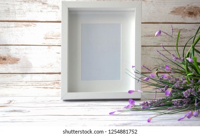 5x7, 8x10 White Frame With Wild Flowers On A White Wood Background.