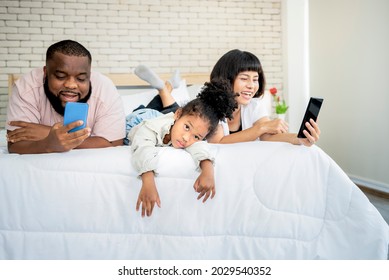 A 5-year-old African-American Girl, Showing Up In A Bad Mood Because Her Parents Are Not Interested, And Using Mobile Phones All The Time, To Family And Social Media Concept.