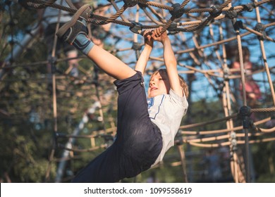 A 5-year-old boy climbs on the ropes at the playground - Powered by Shutterstock