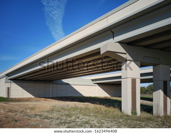 6 concrete I beams in parallel seen from\
below used to support the highway\
above