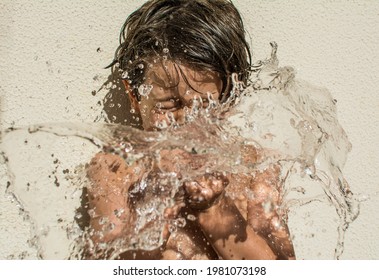 6 Year Old Boy Playing With Water Balloons.
Boy Popping Water Balloons. Summer Concept.