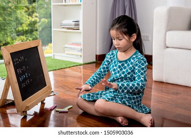 A 6 Year Old Girl Are Counting Fingers To Help Calculate For Practicing Math Broblems On A Small Blackboard At Her House On Vacation, Concept To Child And Education