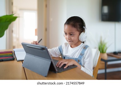 A 6 Years Old Asian Little Student Girl Is Using Tablet For Online Learning Classroom. Concept Of Technology, Internet, Connection, Distance Learning In Worldwide Education And Homeschooling For Kid.