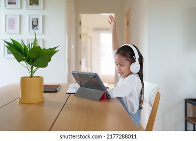 A 6 Years Old Asian Little Student Girl Is Using Tablet For Online Learning Classroom. Concept Of Technology, Internet, Connection, Distance Learning In Worldwide Education And Homeschooling For Kid.