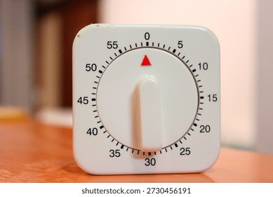 60 Minutes Mechanical Timer Clock Kitchen Cooking Timer Clock With Loud Alarm Clock No Battery Needed. White colored small mechanical clock used for cooking at home. Baking timer or countdown timer.