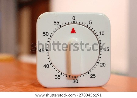 60 Minutes Mechanical Timer Clock Kitchen Cooking Timer Clock With Loud Alarm Clock No Battery Needed. White colored small mechanical clock used for cooking at home. Baking timer or countdown timer.
