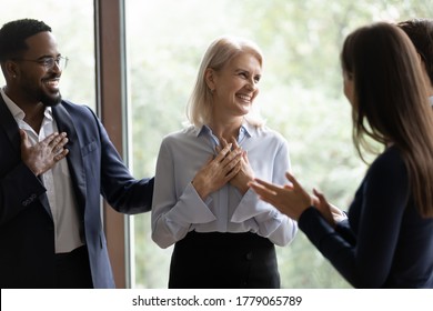 60s businesswoman staff member get praises congrats cheers compliments from multi ethnic colleagues. Promotion career advance, life events birthday celebration, warm relation, kindness from teammates - Powered by Shutterstock