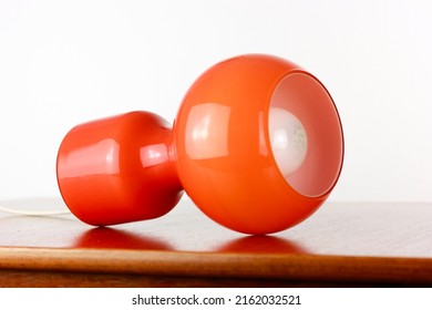 A 60s Modern Orange Bedside Lamp With Glass Spaceage Vintage Midcentury Design Front Side View Isolated On White Background With Warm Orange Light In The Studio Living Room Creative HQ 60s Furniture