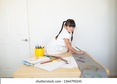 6-7 Years Old Beautiful Child Is Coloring And Drawing On Top Of Table At Home