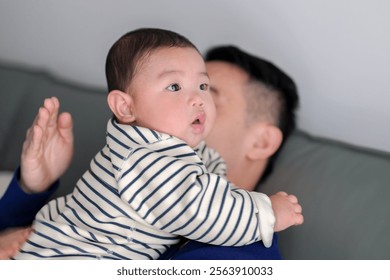 A 6-month-old boy burps while being held by his father from a Chinese family in an apartment building in Pudong New District, Shanghai, China on a cold winter day.
