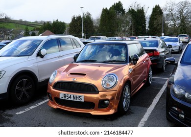6th April 2022- A stylish Mini Cooper S Auto hatchback car, finished with a stunning customised gold coating, parked in a public carpark near the town centre at Carmarthen, Carmarthenshire, Wales, UK.