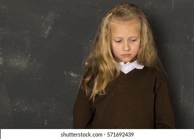 7 Or 8 Years Old Little Beautiful Blond Schoolgirl Sad Moody And Tired In Front Of School Class Blackboard In Child School Education Concept Isolated On White Background 