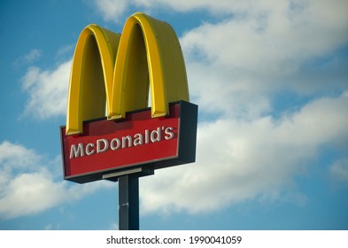 7 March 2021, Luton, England, UK - McDonald's Logo Surrounded By Blue Sky And Clouds