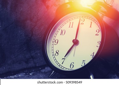 7 o'clock vintage clock at dark color tone with sun light memory time concept.