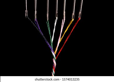 7 steel sewing needles threaded with various colored threads which are twisted into a simble thick thread.  There is room for copy both left and right of the thread