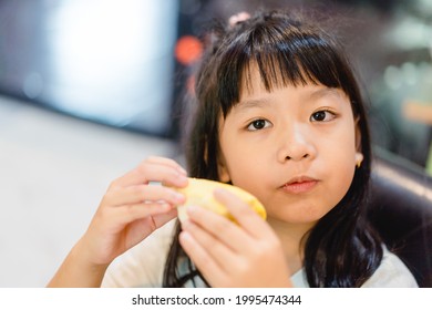 7 years old asian kid girl eat fresh fruit.Little asian thai girl eating durian fruit at home delicious.She make every happy and yummy face.Sweet and creamy durian.Durians are the king of fruits.