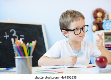 7 years old boy solves multiplication table in his copybook and counting on fingers. Back to school - Shutterstock ID 469501838