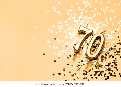 70 years celebration festive background made with golden candles in the form of number Seventy lying on sparkles. Universal holiday banner with copy space.