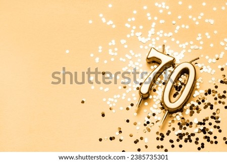 70 years celebration festive background made with golden candles in the form of number Seventy lying on sparkles. Universal holiday banner with copy space.