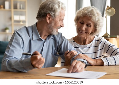70s couple sit at table indoor discuss agreement term and condition feels satisfied make financial deal ready to sign contract, bequeath savings and property to their children or grandchildren concept