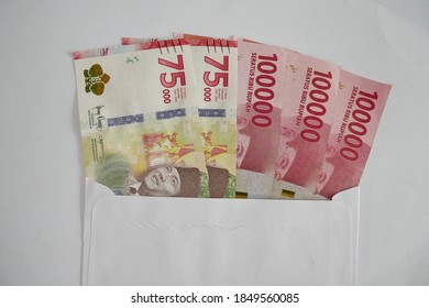 75000 And 100000 Rupiah Banknotes In An Envelope. Illustration Of Payment Of Salaries, Bonuses, Holiday Allowances, Overtime.