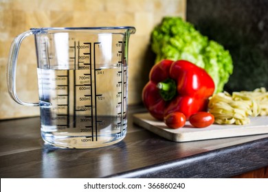 750ccm / 3/4 Liter / 750ml Of Water In A Measuring Cup On A Kitchen Counter With Food