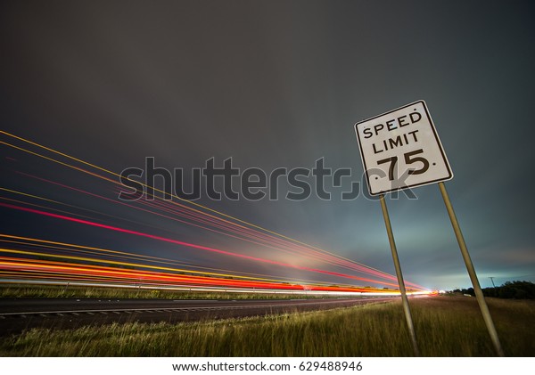 75np\
speed limit sign at night next to afreeway at\
night