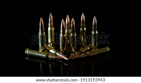 7.62mm ammunition cartridges standing and laid down on black background 