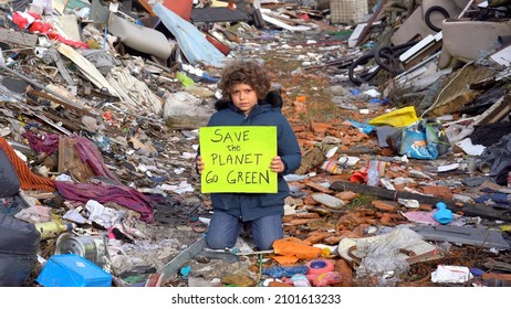 7-year-old Child Environmentalist And Ecologist Holding A Sign With The Words Save The Planet Go Green, Protest Against Climate Change, Global Warming And Atmospheric Pollution In A Garbage Dump 