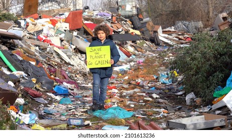 7-year-old Child Environmentalist And Ecologist Holding A Sign With The Words Save The Planet Go Green, Protest Against Climate Change, Global Warming And Atmospheric Pollution In A Garbage Dump 