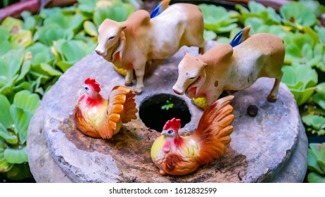 8 JANUARY 2020; Statues Of Cows And Chickens Resting On A Flower Pot Base, At Chaing Rai Thailand.