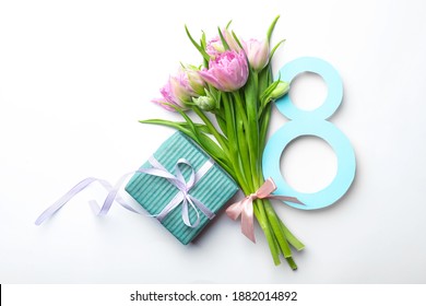 8 March greeting card design with tulips and gift on white background, top view
