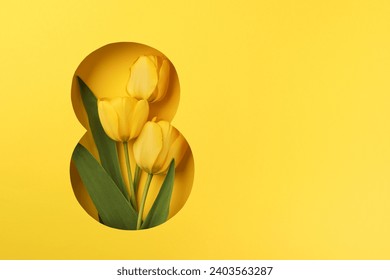 8 March greeting card. Paper cut Eight made of yellow background and fresh spring flowers bouquet of yellow tulips. Greeting card for Womens Day on March 8 Flat lay top view. International Womens day