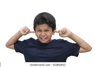 8 year old boy with expression of being upset with the noise of loud music